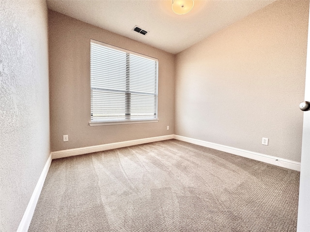 carpeted spare room with a textured ceiling and vaulted ceiling