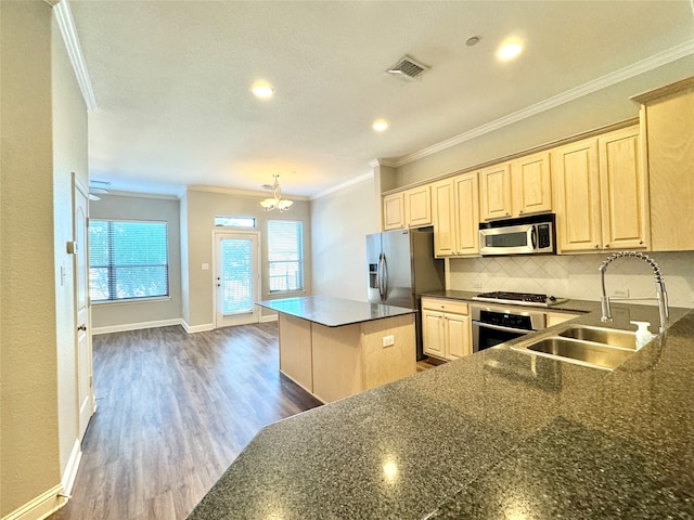 kitchen with sink, ornamental molding, dark hardwood / wood-style flooring, stainless steel appliances, and a chandelier