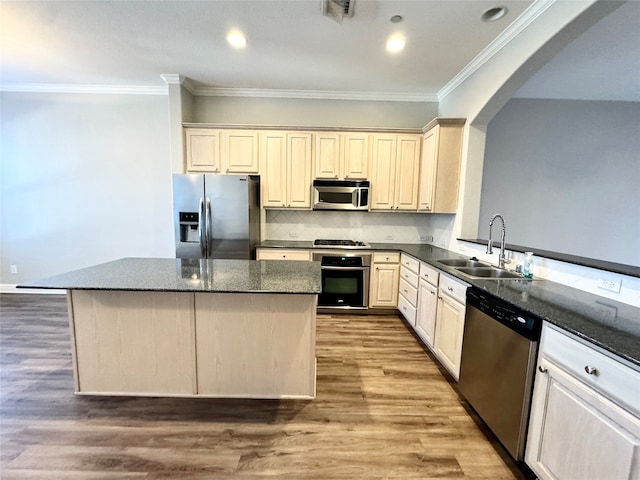 kitchen with appliances with stainless steel finishes, light hardwood / wood-style floors, dark stone counters, and sink