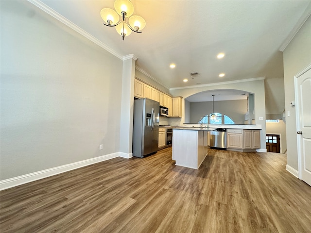 kitchen featuring pendant lighting, dark wood-type flooring, ornamental molding, stainless steel appliances, and a chandelier