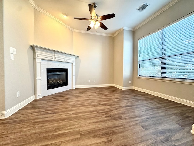 unfurnished living room with ceiling fan, dark hardwood / wood-style flooring, a premium fireplace, and crown molding