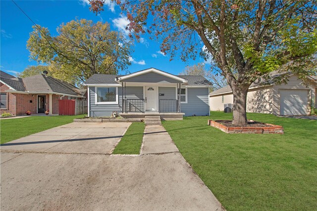 view of front of house with an outdoor structure, a porch, and a front yard