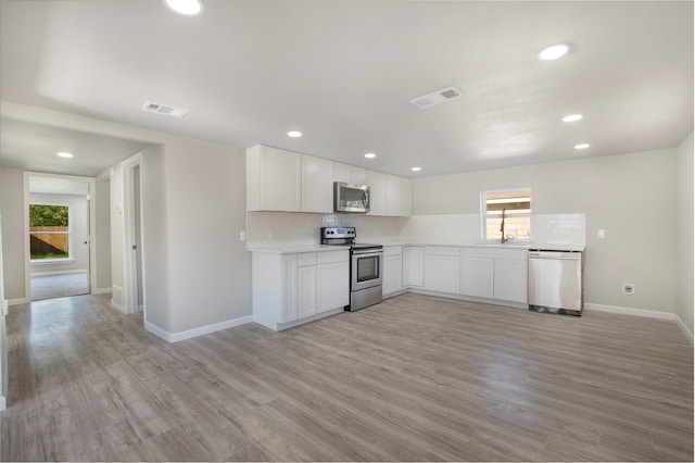 kitchen with white cabinetry, plenty of natural light, stainless steel appliances, and light wood-type flooring