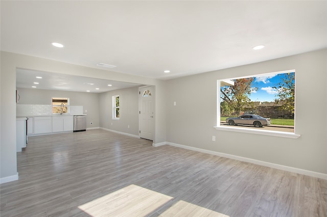 unfurnished living room with light hardwood / wood-style flooring and a healthy amount of sunlight