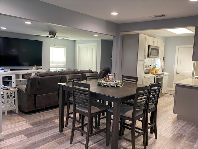 dining area featuring ceiling fan and light wood-type flooring