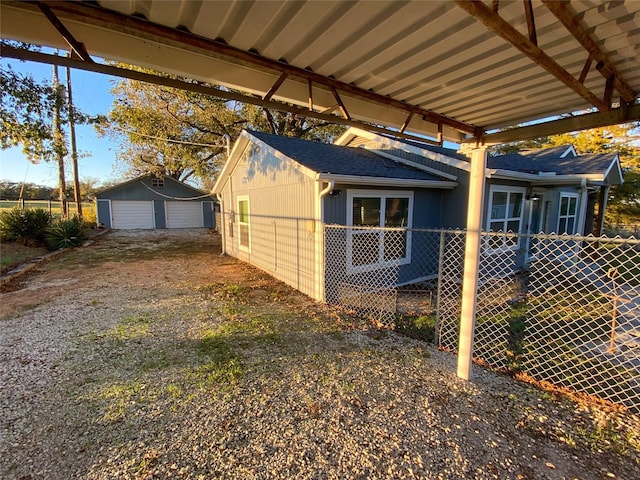 view of side of home featuring a garage and an outbuilding