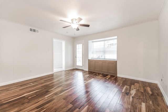 empty room featuring ornamental molding, ceiling fan, and dark wood-type flooring