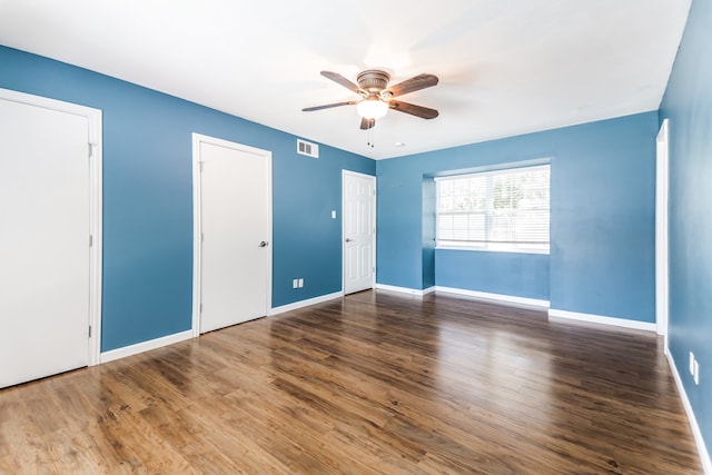 spare room with ceiling fan and dark wood-type flooring