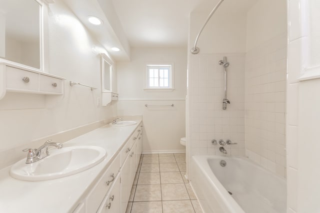 full bathroom with tile patterned floors, vanity, tiled shower / bath combo, and toilet