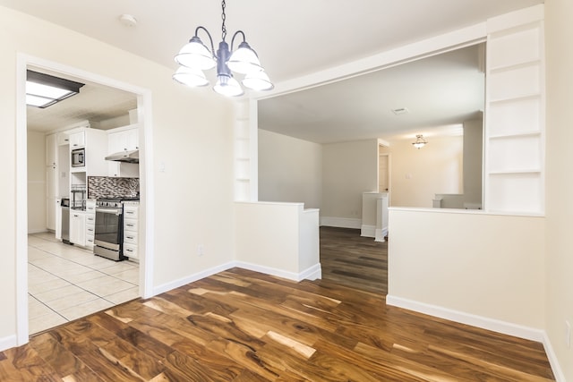 unfurnished dining area with hardwood / wood-style flooring and a notable chandelier