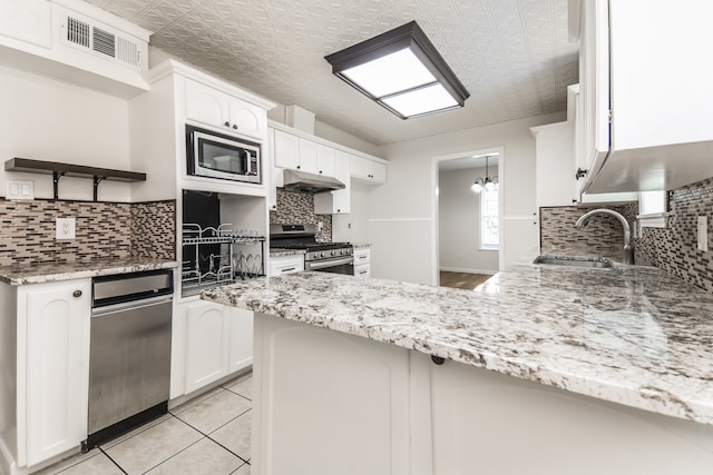 kitchen with sink, tasteful backsplash, kitchen peninsula, white cabinets, and appliances with stainless steel finishes