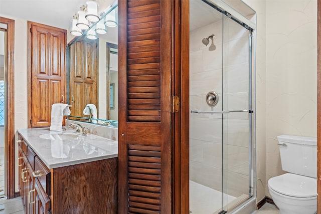 bathroom featuring vanity, an enclosed shower, and toilet