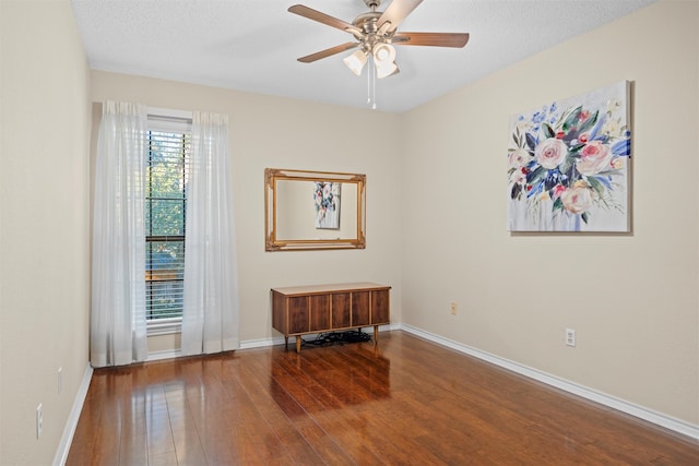 unfurnished room with ceiling fan, wood-type flooring, and a textured ceiling