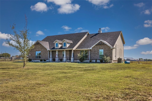 view of front of property with central AC and a front lawn