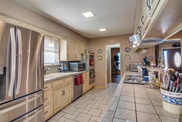 kitchen with appliances with stainless steel finishes, backsplash, decorative light fixtures, and sink