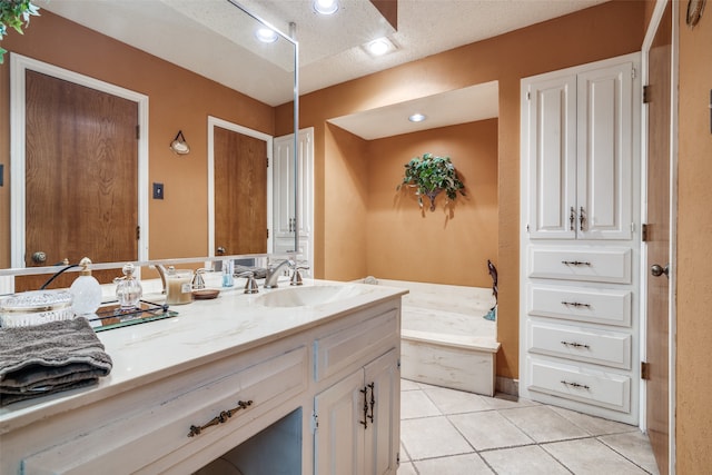 bathroom with tile patterned floors, vanity, a bath, and a textured ceiling