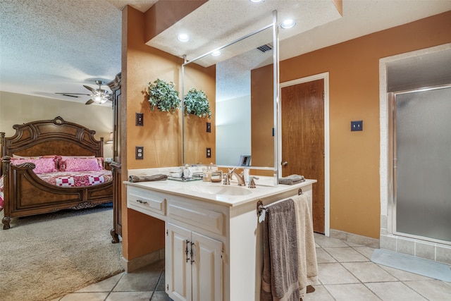 bathroom featuring vanity, tile patterned floors, ceiling fan, a textured ceiling, and a shower with shower door