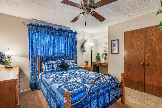 carpeted bedroom with ceiling fan and a textured ceiling