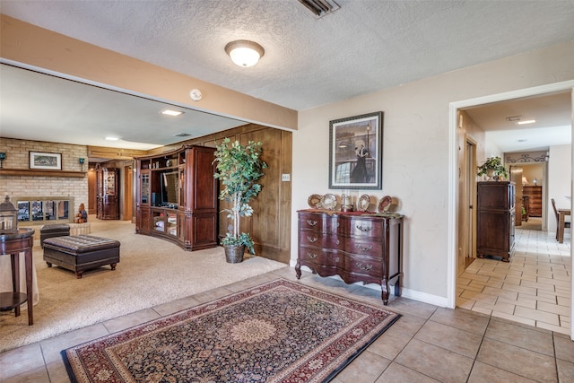 interior space featuring light tile patterned floors, a textured ceiling, and wooden walls