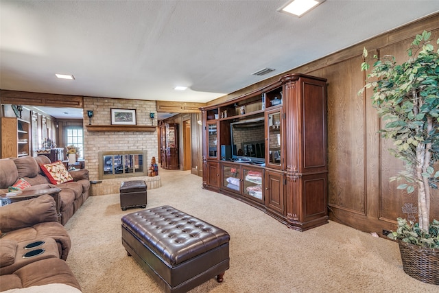 living room featuring wooden walls, a fireplace, carpet, and a textured ceiling