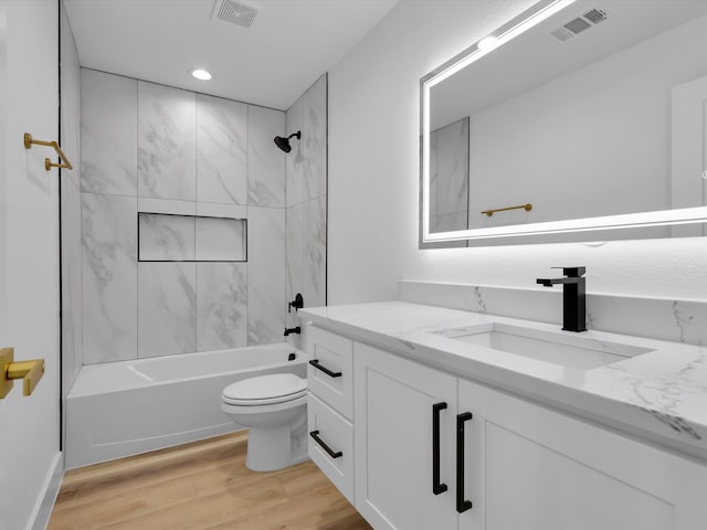 full bathroom featuring vanity, toilet, tiled shower / bath, and hardwood / wood-style flooring