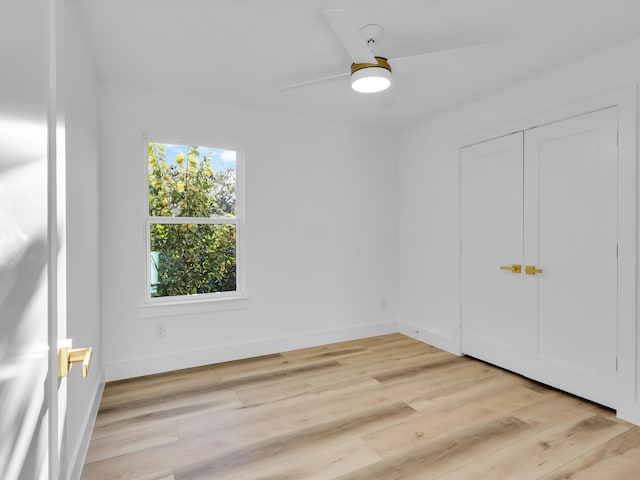 unfurnished bedroom featuring ceiling fan, a closet, and light hardwood / wood-style flooring