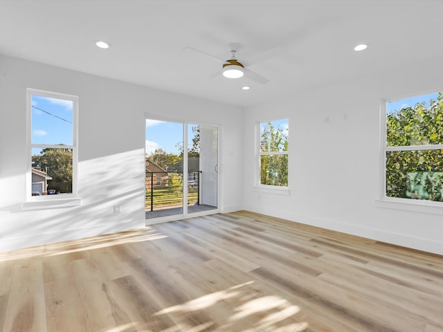 empty room featuring ceiling fan, light hardwood / wood-style flooring, and a healthy amount of sunlight