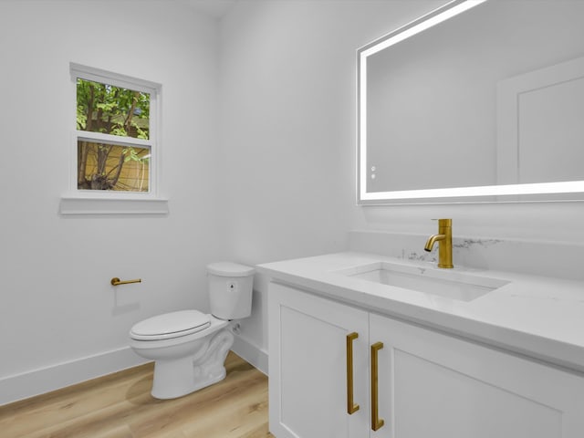 bathroom with hardwood / wood-style floors, vanity, and toilet