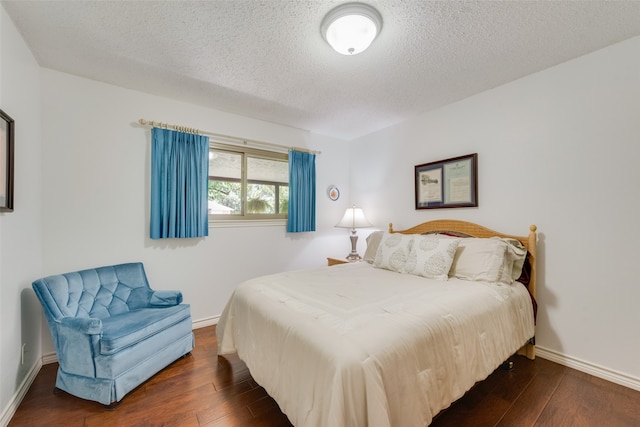 bedroom featuring a textured ceiling and dark hardwood / wood-style floors