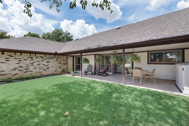 rear view of property with a yard and a patio area