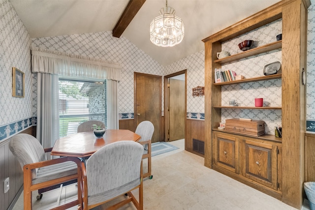 dining space with lofted ceiling with beams and a chandelier