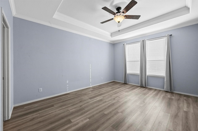 spare room featuring hardwood / wood-style floors, crown molding, and a tray ceiling