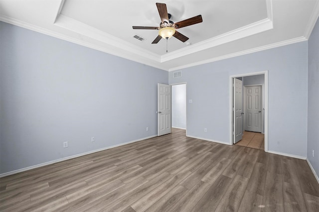 unfurnished bedroom with a raised ceiling, light hardwood / wood-style flooring, ceiling fan, and ornamental molding