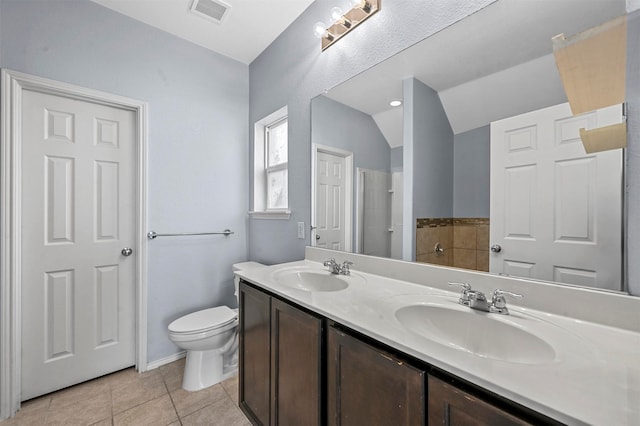 bathroom featuring tile patterned flooring, vanity, toilet, and lofted ceiling