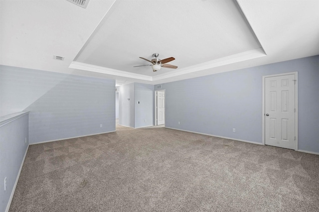 carpeted empty room with a tray ceiling and ceiling fan