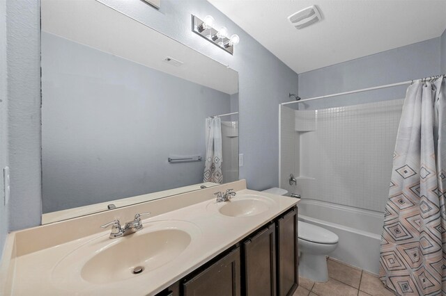 full bathroom featuring shower / bath combo with shower curtain, tile patterned flooring, vanity, and toilet