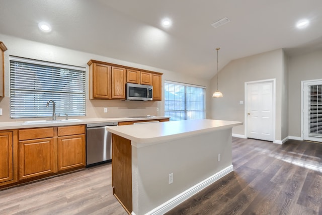 kitchen featuring dark hardwood / wood-style floors, a center island, lofted ceiling, and stainless steel appliances