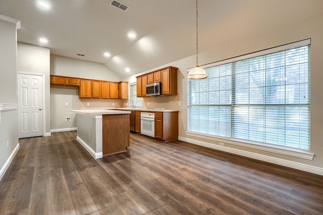 kitchen featuring oven, vaulted ceiling, decorative light fixtures, a kitchen island, and dark hardwood / wood-style flooring