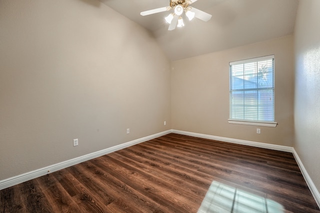 empty room with dark hardwood / wood-style flooring, vaulted ceiling, and ceiling fan