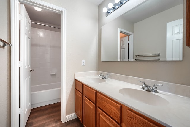 bathroom featuring hardwood / wood-style flooring, vanity, and shower / bathing tub combination