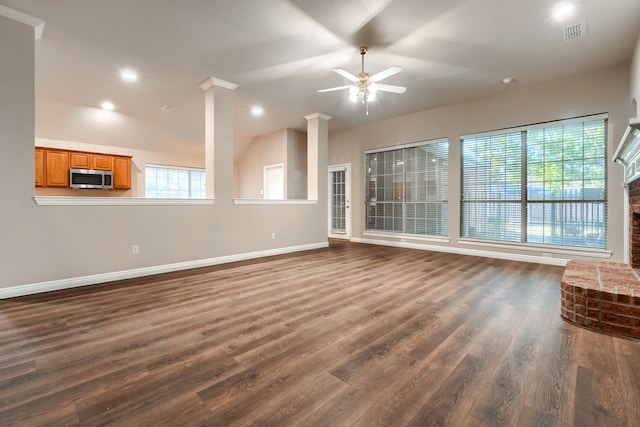 unfurnished living room with dark hardwood / wood-style floors, a brick fireplace, and ceiling fan