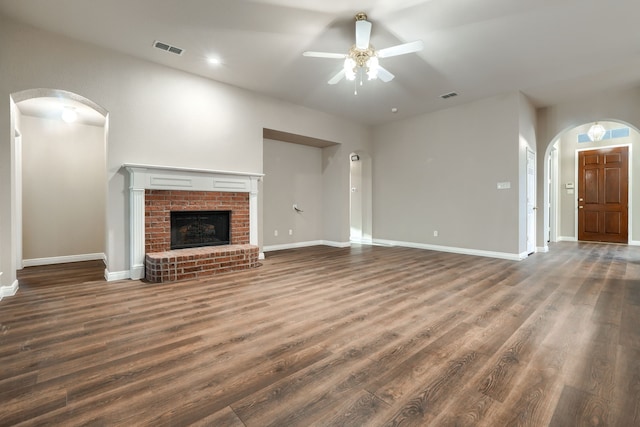 unfurnished living room with a fireplace, ceiling fan, and dark hardwood / wood-style flooring