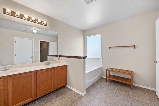 bathroom with tile patterned flooring, vanity, and a bathing tub