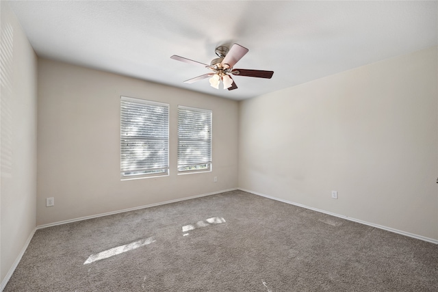 spare room with ceiling fan and carpet