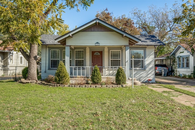 bungalow with a porch and a front lawn