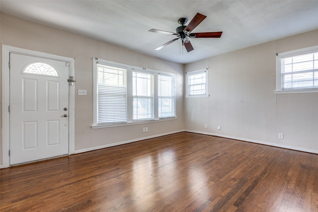 entrance foyer with ceiling fan, dark wood-type flooring, and a wealth of natural light