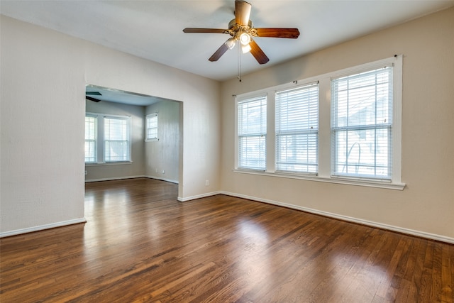 unfurnished room featuring dark hardwood / wood-style floors, ceiling fan, and a healthy amount of sunlight