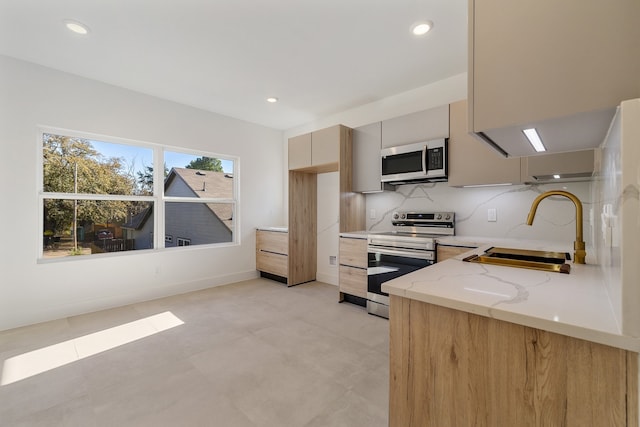 kitchen with backsplash, sink, light stone countertops, light brown cabinetry, and stainless steel appliances