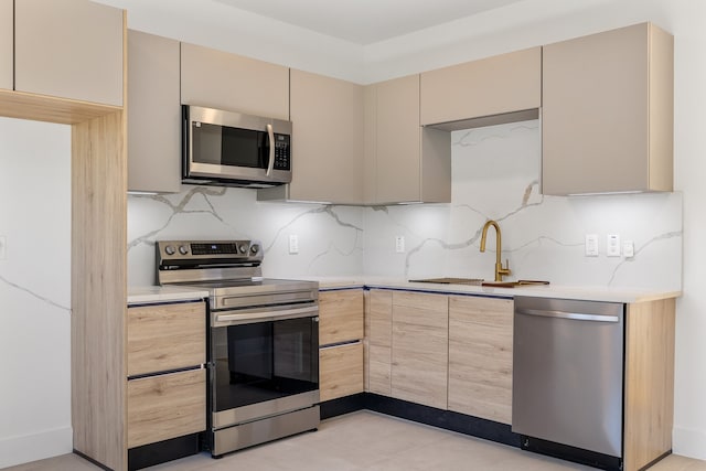 kitchen with light brown cabinets, sink, appliances with stainless steel finishes, and tasteful backsplash