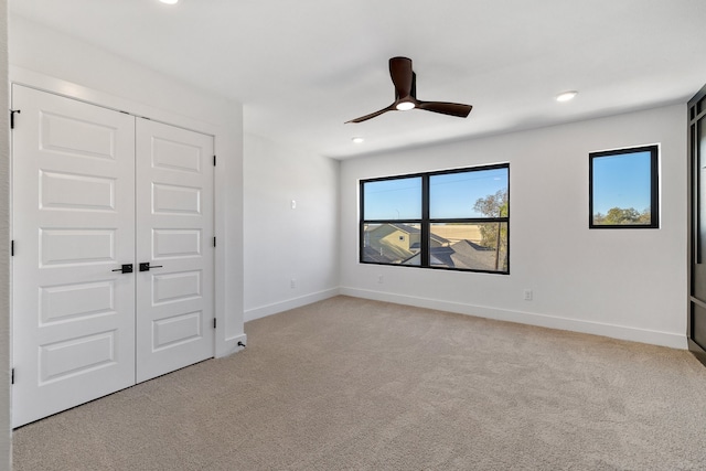 empty room with ceiling fan and light carpet